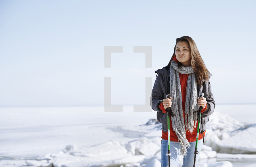 a young woman hiking through a snow covered landscape 