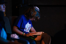 young boy reading during a service 