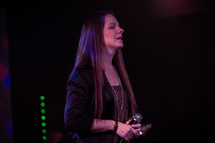 female worship leader singing on stage 