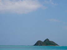 A mountain island rises above the ocean.