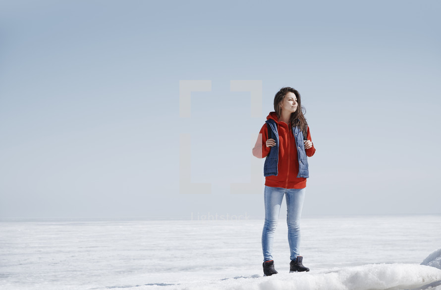 a young woman standing in snow 