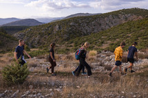 small group of young adults hiking along a ridge in the mountains