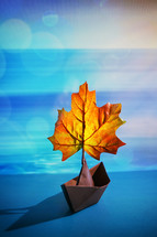 Abstract Paper Boat With A Maple Leaf On A Pond