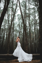 a bride standing in a forest 