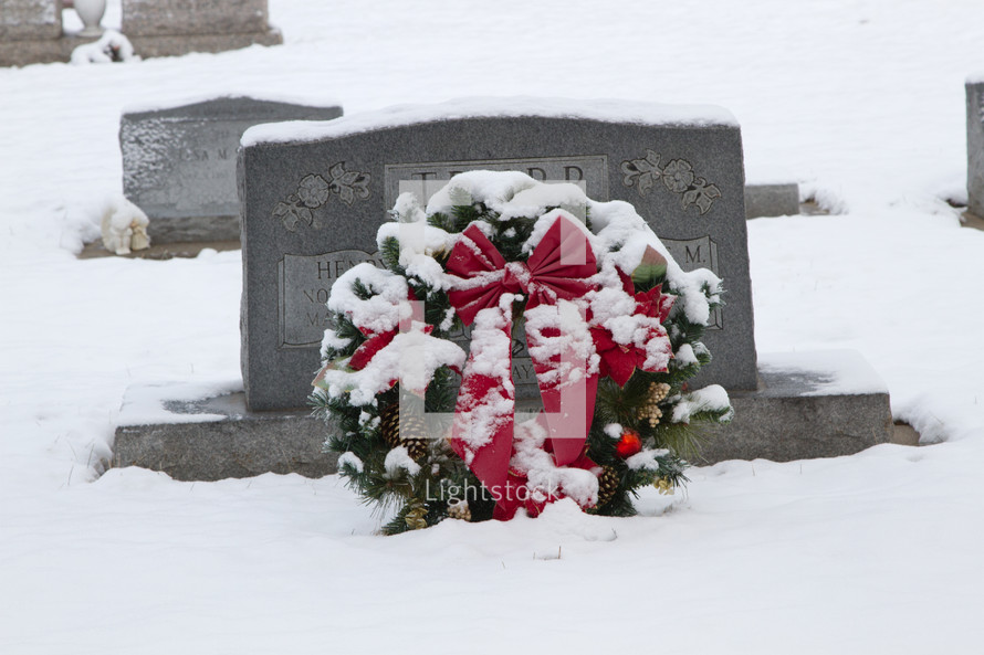 Christmas wreath in snow on a grave 