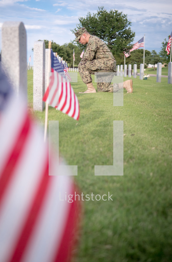 solider praying at Arlington National Cemetery 