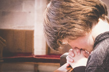 praying boy in a church pew 