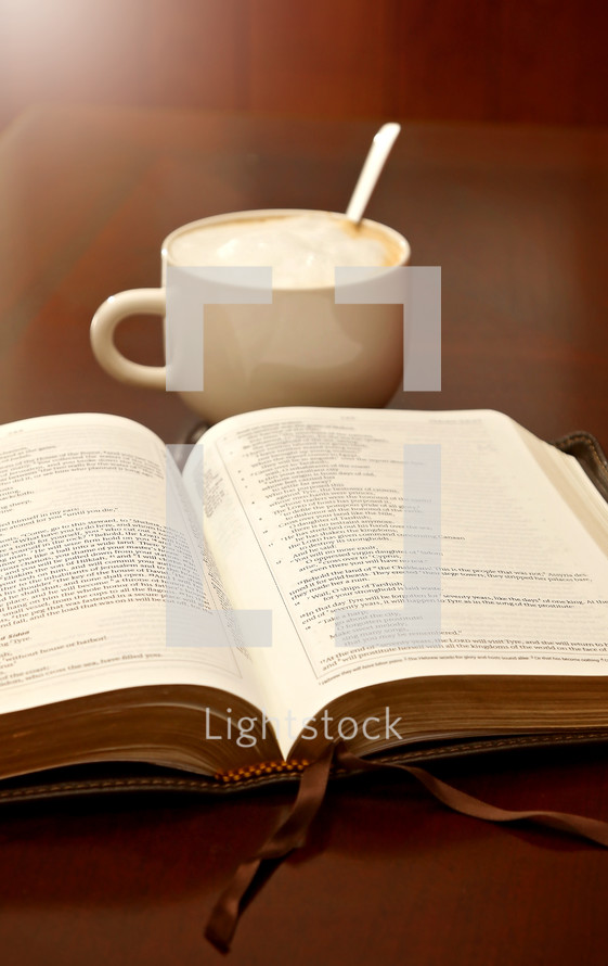 open Bible and coffee on a wood table 