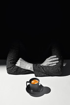 Woman crossing arms with coffee in mug