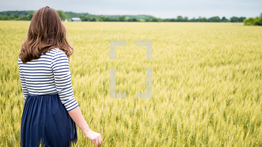 woman standing in a wheat field 