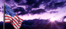 American flag and purple clouds at sunrise 