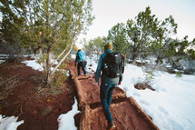 men backpacking on a path through snow 