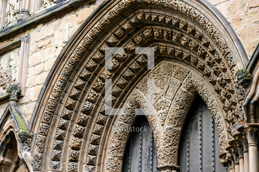 decorative stone archway over a cathedral door 