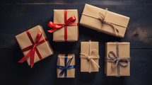 Simple Christmas gifts wrapped in brown paper on a dark wood background. 