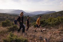 small group of young adults hiking along a ridge in the mountains