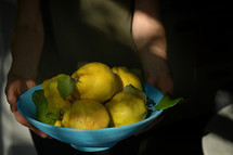 Holding a bowl of yellow pears