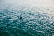 man sitting on a surfboard in the ocean 