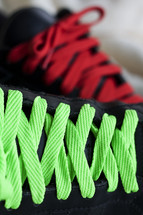 green and red shoe laces on a pair of black shoes