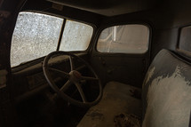 Interior of dirty, vintage truck in a barn