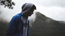 man in a hoodie on a mountain top 