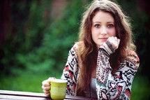 a young woman sitting drinking coffee 