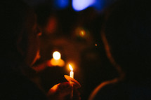 people holding candles at a candlelight service 
