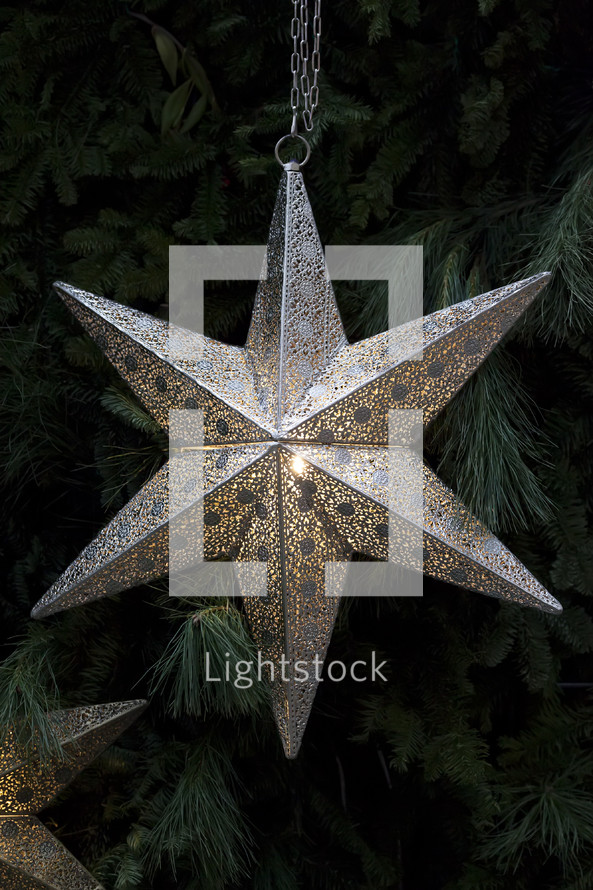 silver star ornament on a Christmas tree 