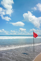 red flag warning on a beach 