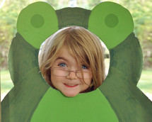 little girl in a funny frog cutout 