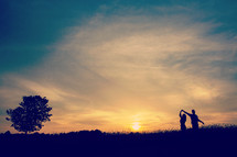silhouette of a couple dancing at sunset 