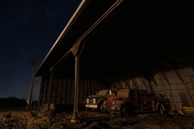 Vintage trucks in barn at night