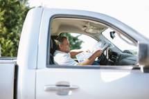 a man in a truck reading a newspaper 