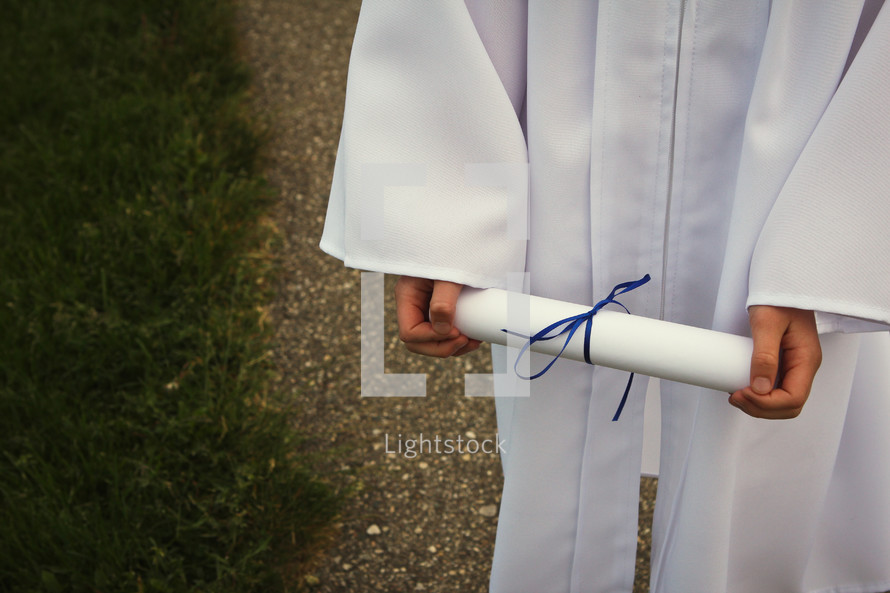 girl in cap and gown holding a diploma 