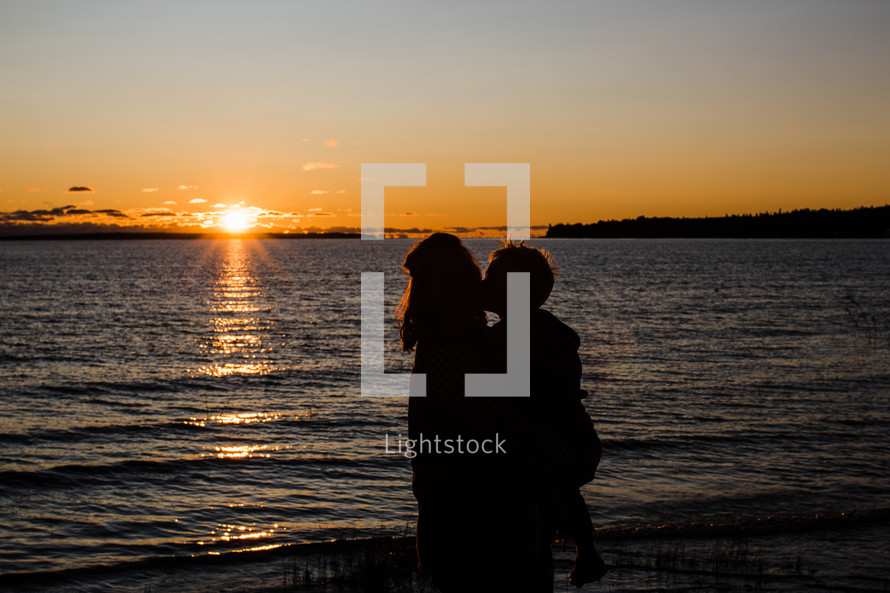 silhouette of mother and son at sunset 