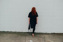 redhead woman standing in front of a white wall 