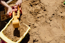 a boy playing in a sandbox 