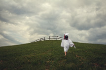 girl walking up a hill carrying a diploma 