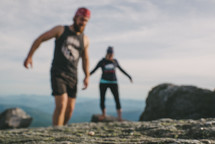 man and woman hiking on a mountaintop 
