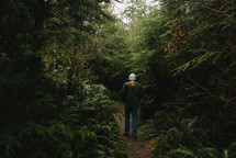 a man standing in a forest alone 
