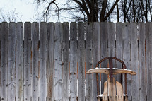 a sled leaning against a wooden fence 