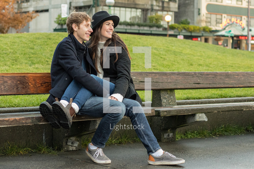 a couple sitting on a bench downtown 