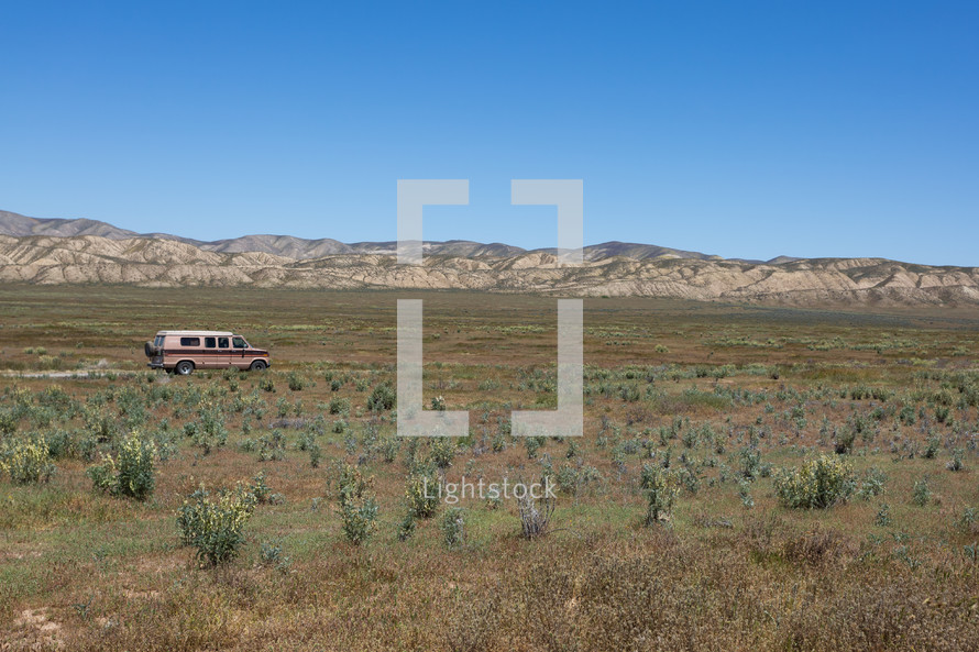 van on a dirt road in the desert 