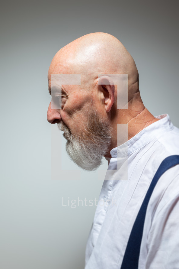 side profile of a senior man in suspenders 