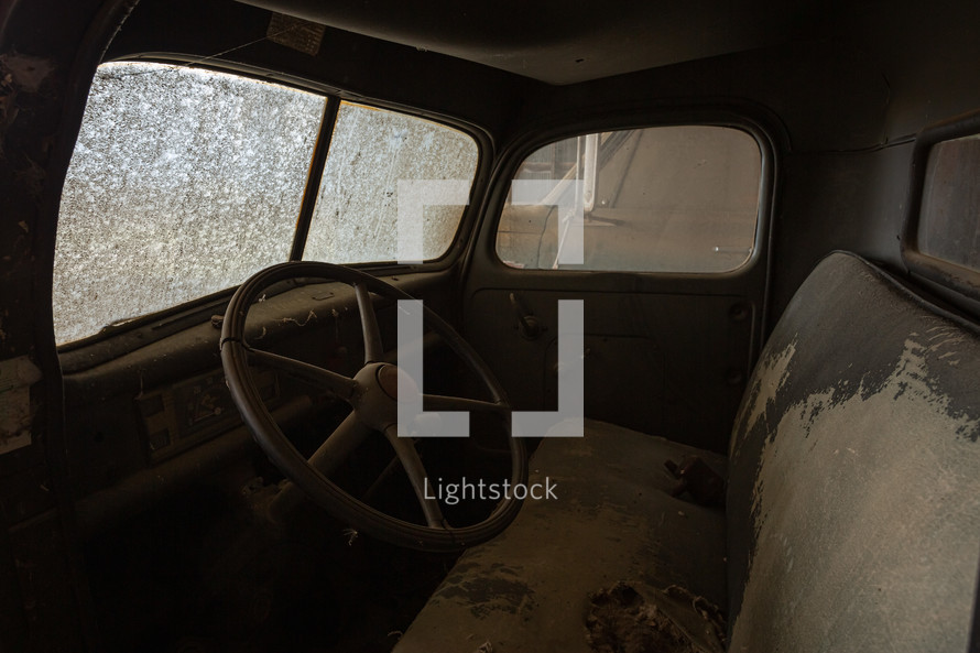 Interior of dirty, vintage truck in a barn