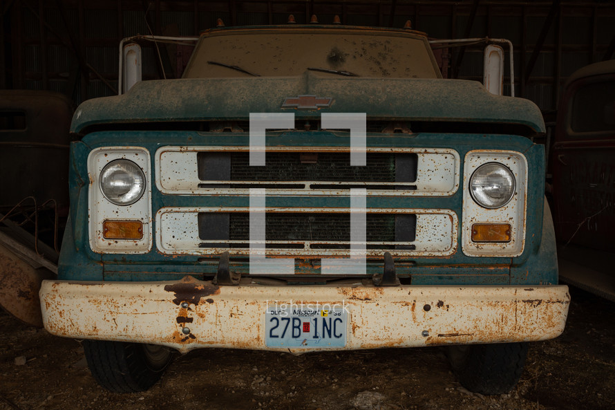 Green, vintage truck in a barn