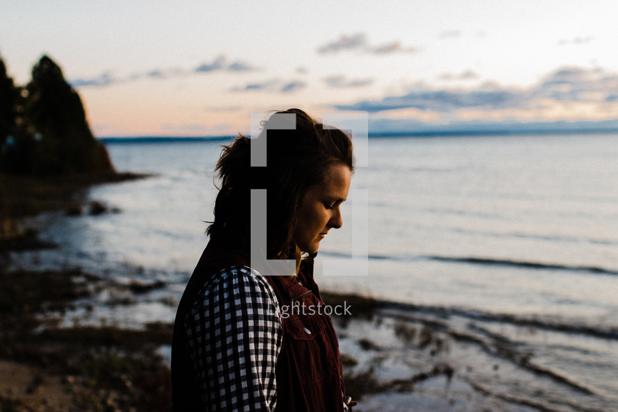woman praying by a shore 