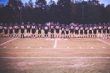 football team praying on the sidelines 
