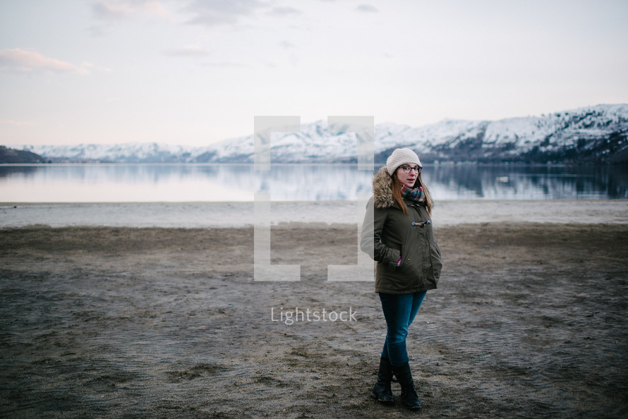 a woman standing by a lake 