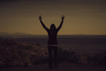 silhouette of a woman with raised hands 