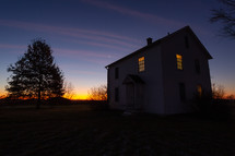 Farm house and tree at sunset